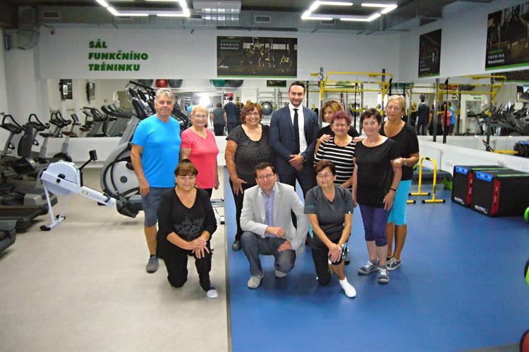 Senioři pokračují ve cvičení ve fitness centru.